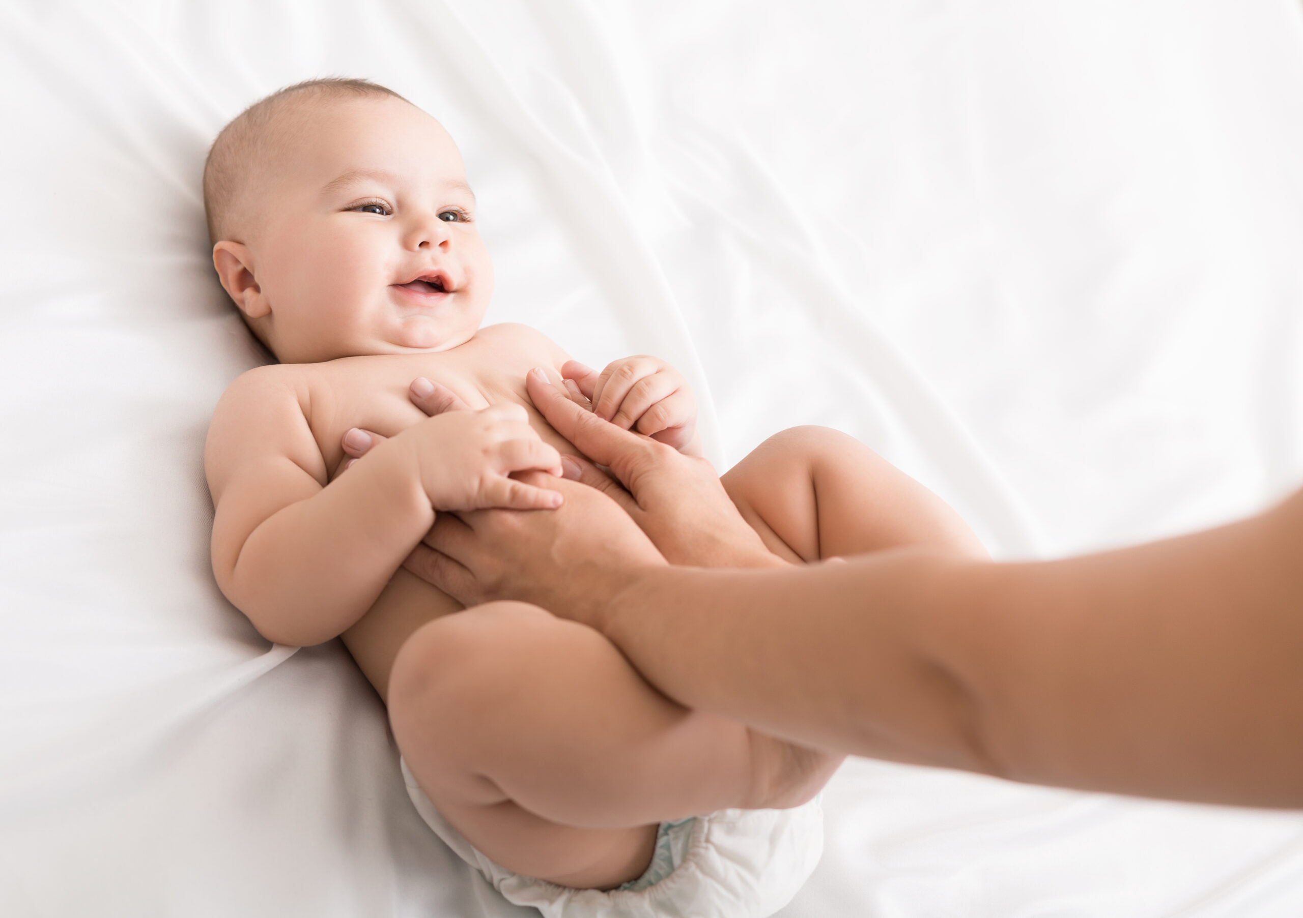 Professional masseur doing massage to newborn baby